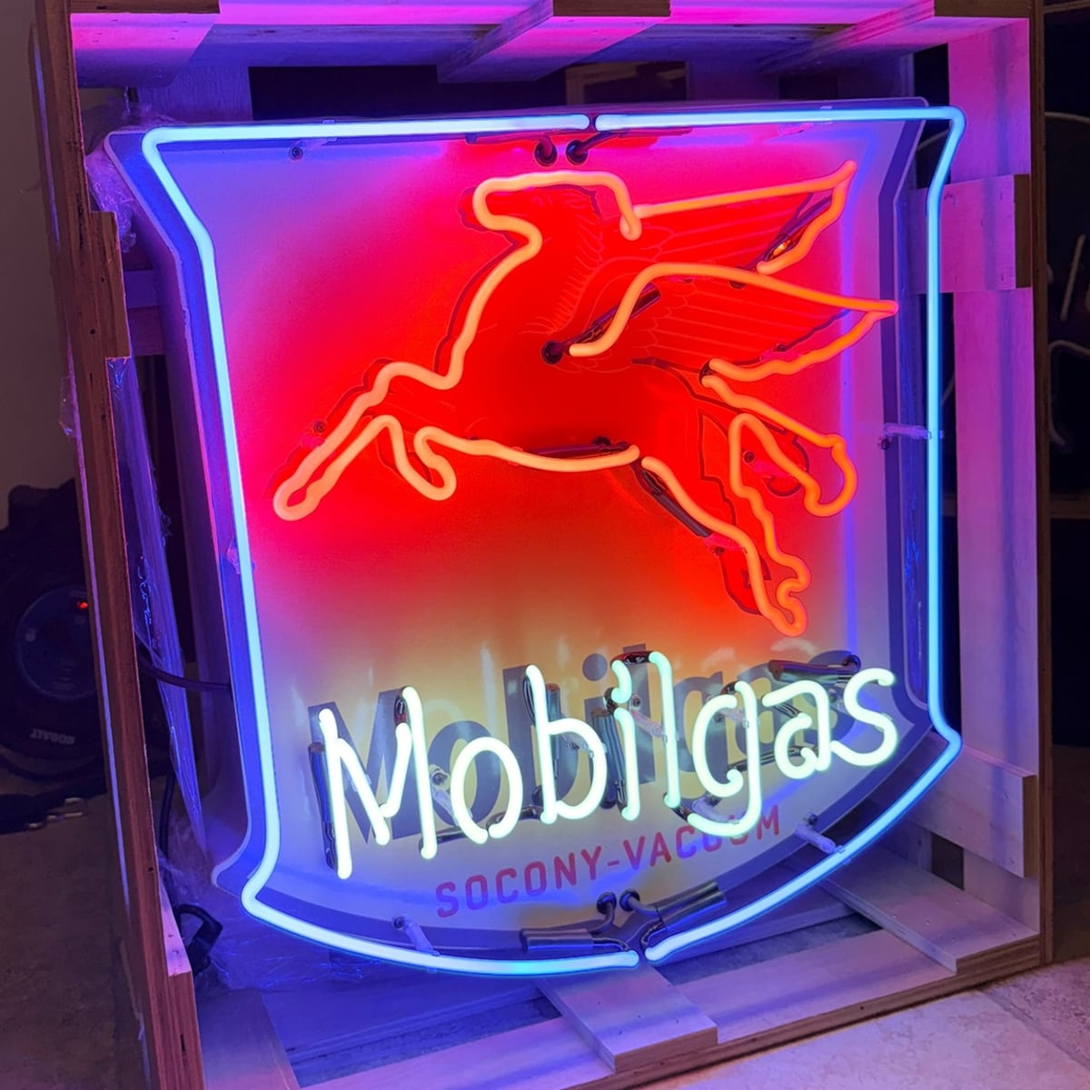 Archived catalog photograph of an illuminated shield-shaped Mobilgas display with a red flying horse, blue border, and white lettering