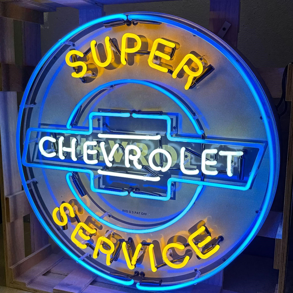 Actual catalog photograph of an illuminated round Super Chevrolet Service advertising display in blue, white, and yellow neon