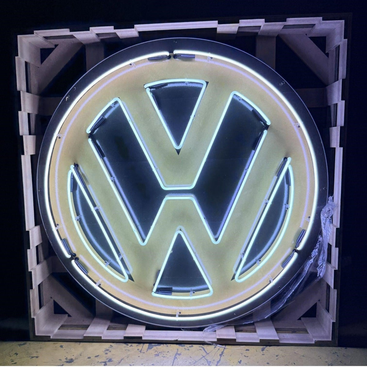 Actual catalog photograph of an illuminated round Volkswagen-logo display with white neon outlining a black VW emblem