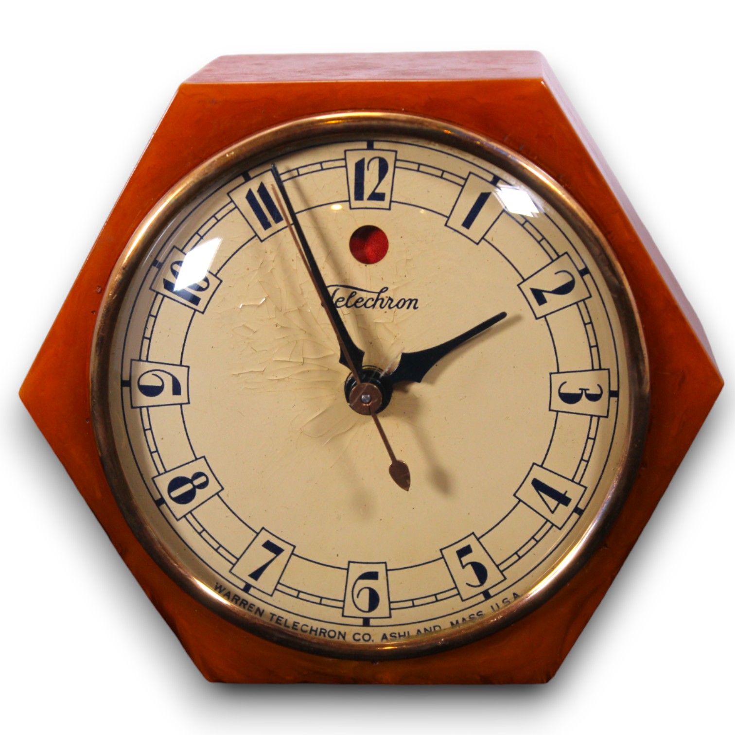 Catalog photograph of an orange geometric tabletop clock with a round cream dial